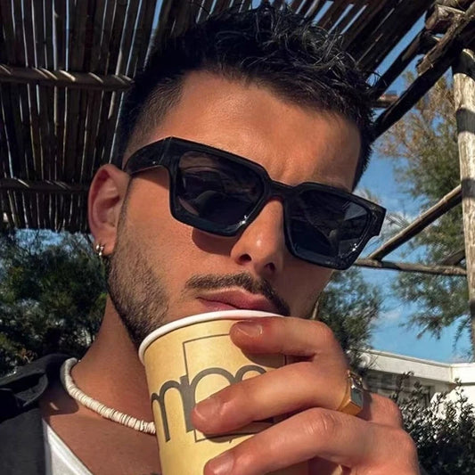 Square sunglasses with black frame and dark lenses, worn look on face.
