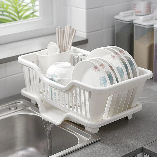 White countertop dish drying rack with drainer board, holding plates and utensils over sink