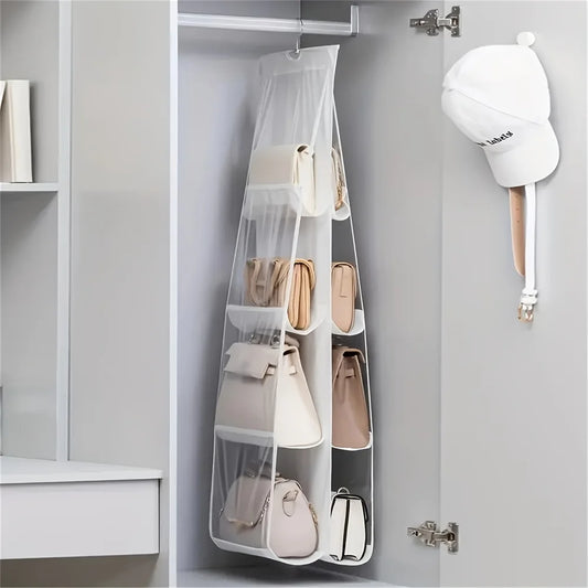 White hanging handbag organizer with clear mesh pockets holding multiple handbags