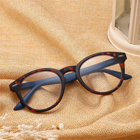 Retro oval reading glasses with dark blue and black frames, clear lenses