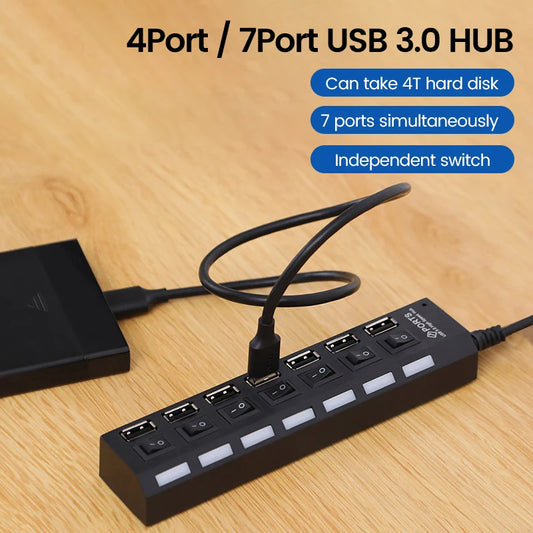 Black multi-port USB hub with cable and independent switches on a desk