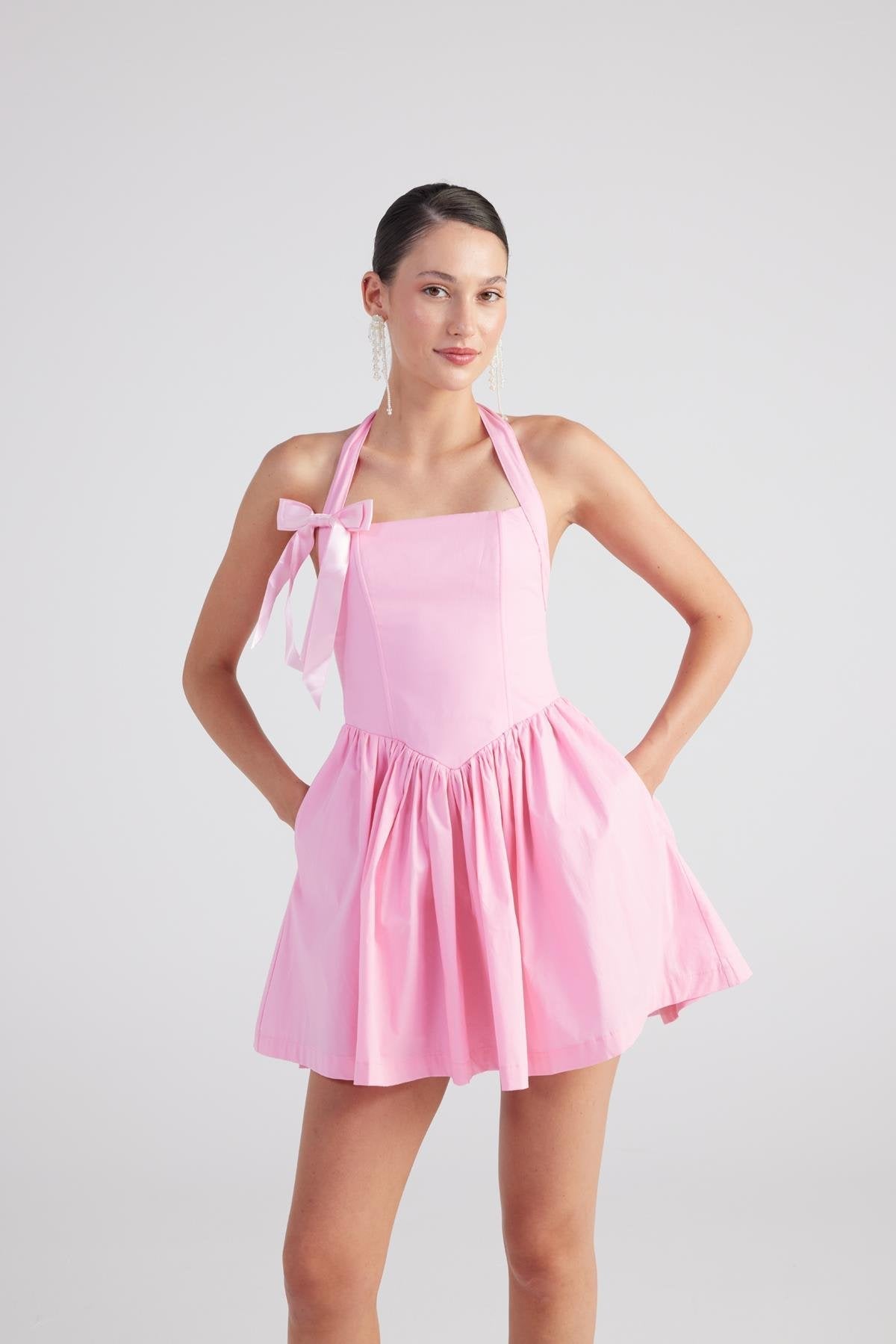 Pink halter mini dress with pleated skirt and bow tie shoulder straps