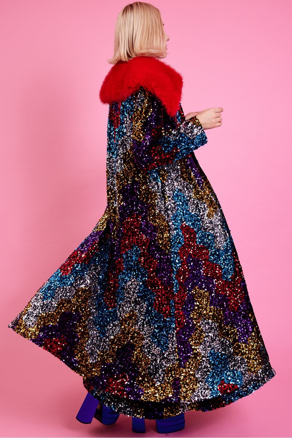 Long sequin trench coat in dark black with red faux fur collar, three-quarter back view