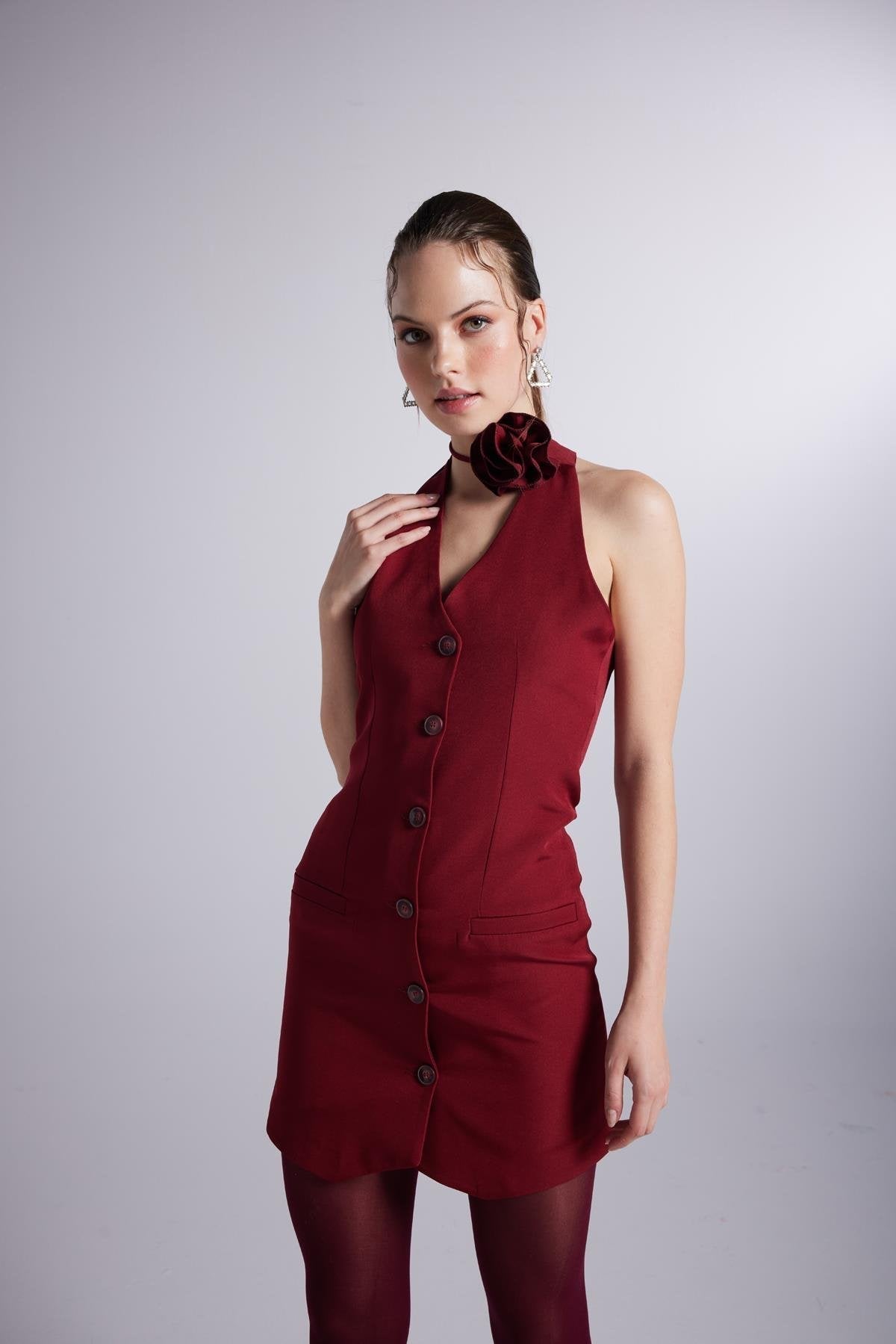 Burgundy sleeveless mini dress with V-neck, button front, and rose detail at collar