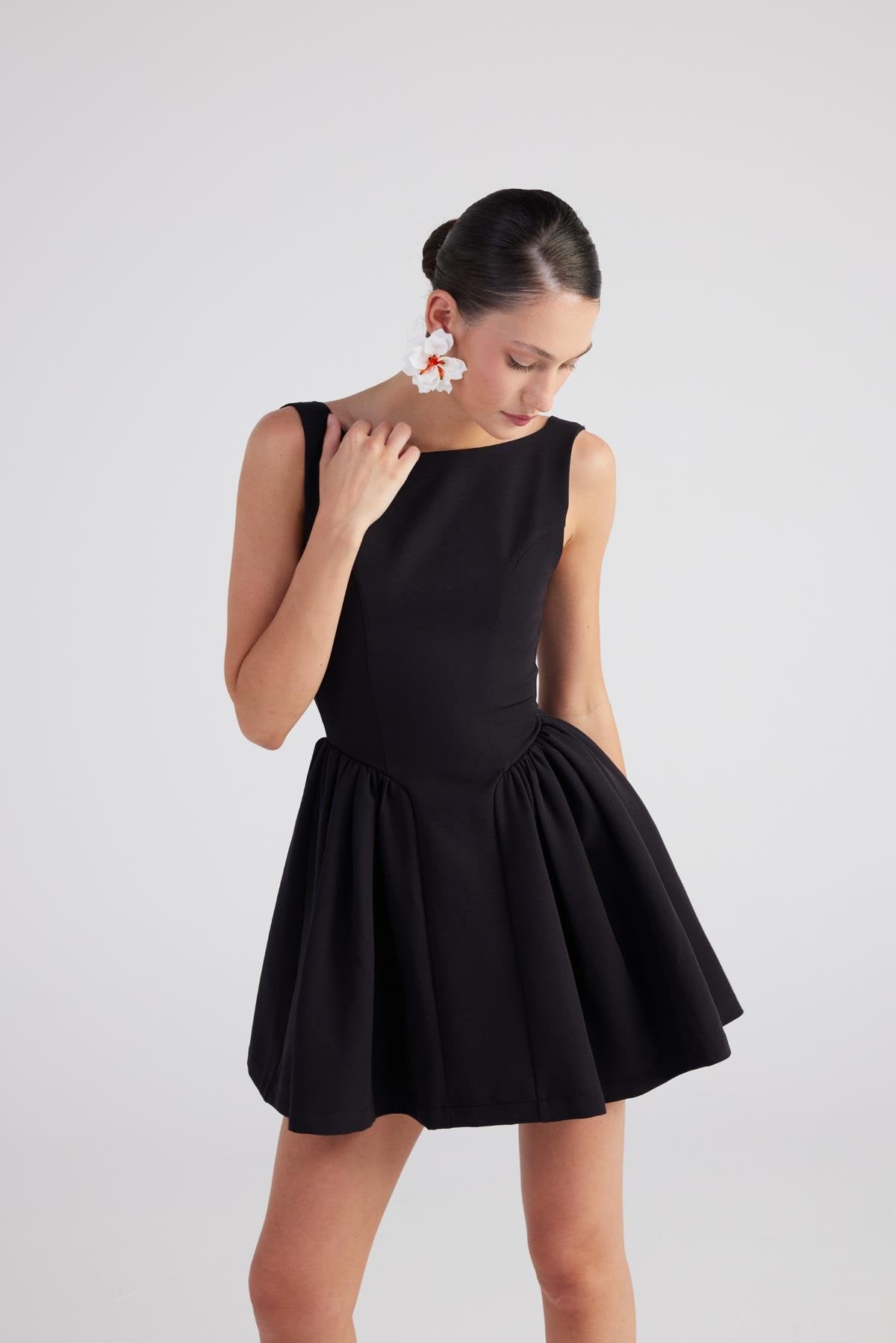 Black sleeveless pleated mini dress with scoop neckline and gathered waist