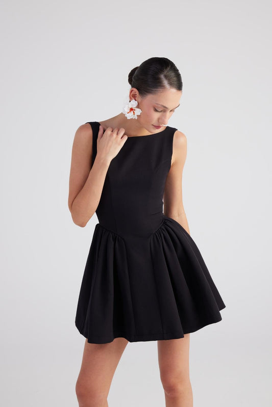 Black sleeveless pleated mini dress with scoop neckline and gathered waist