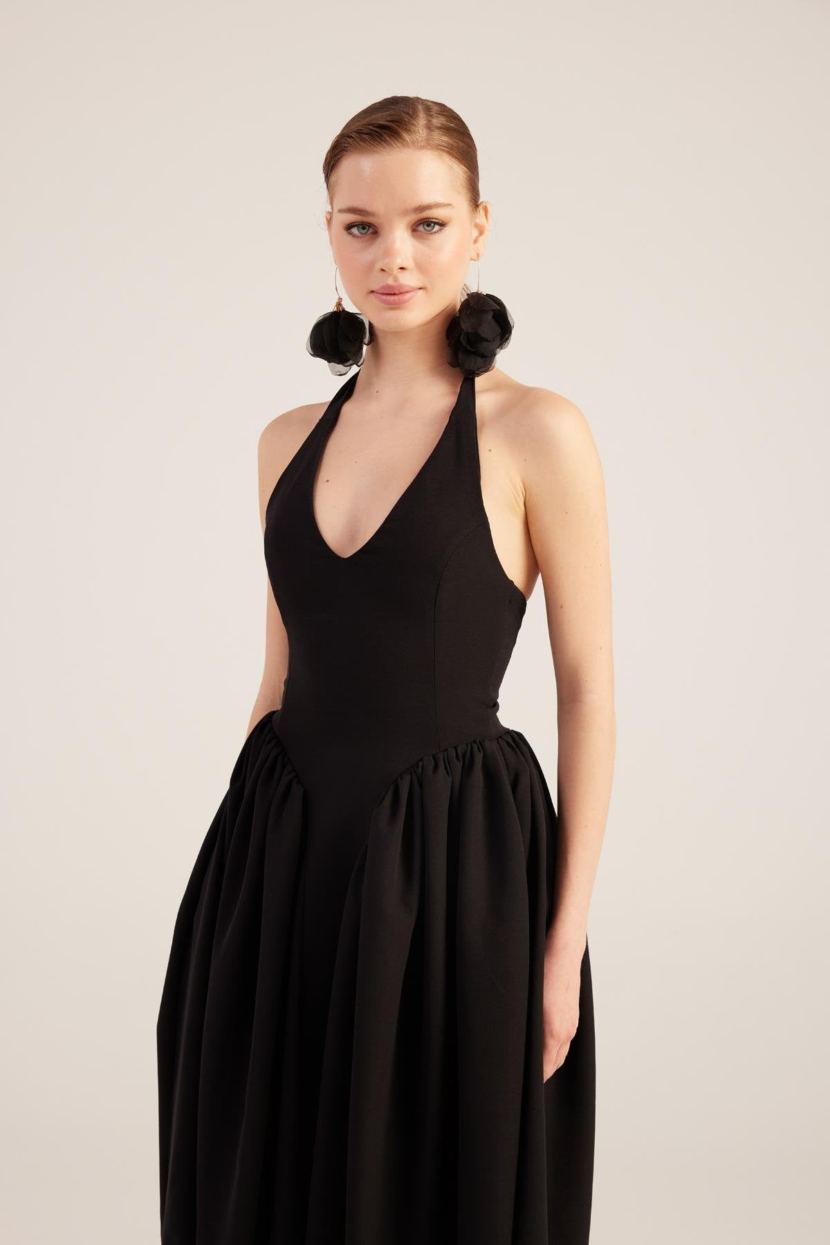 Black halter maxi dress with deep V neckline and gathered skirt
