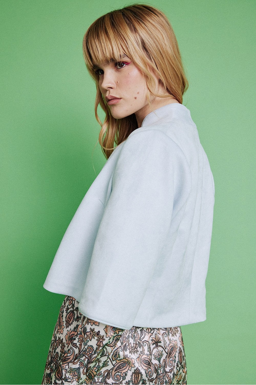 Light gray faux suede cropped jacket, side view with zip front and wide sleeves