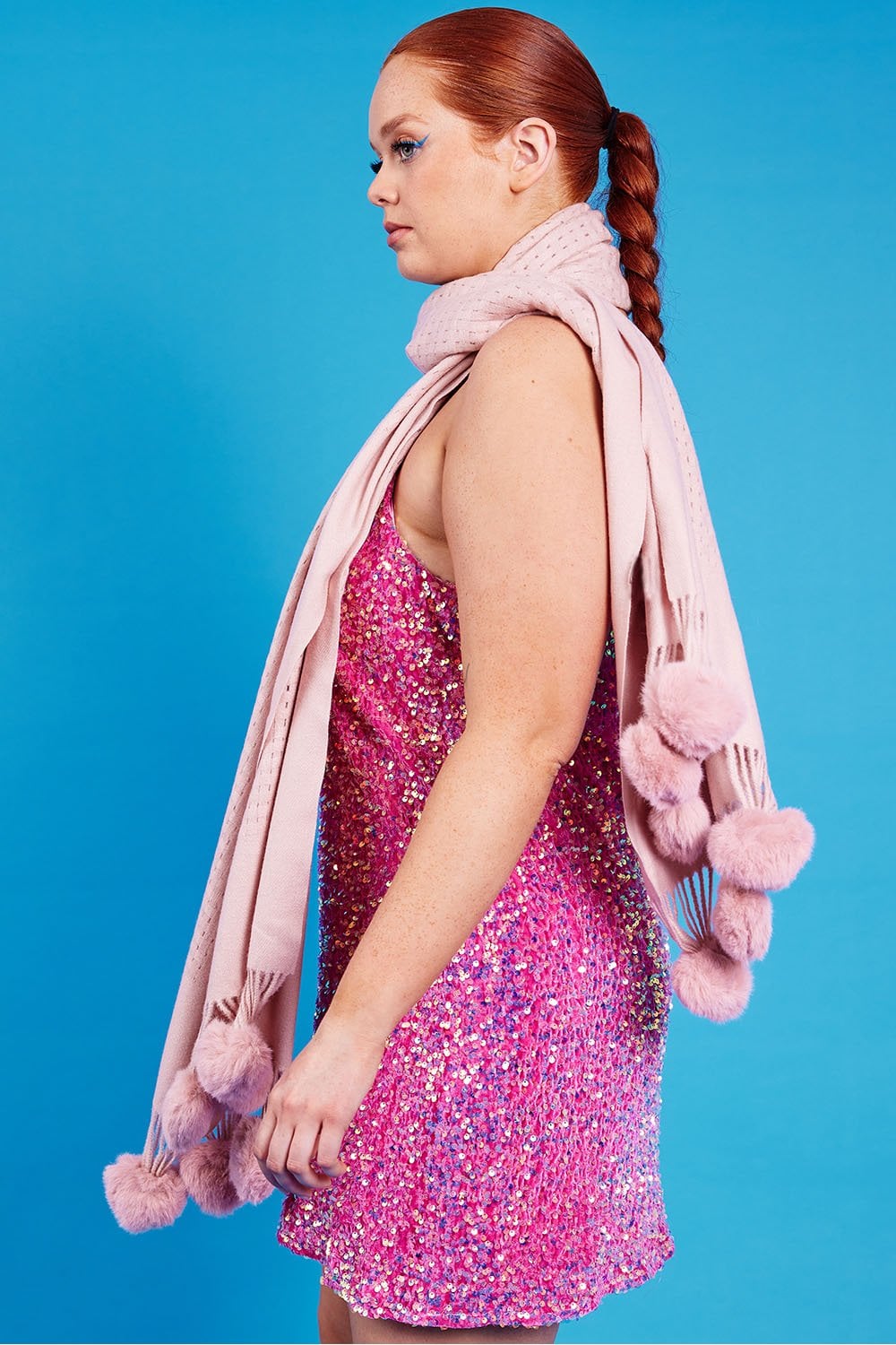 Pink sequined cami dress side view with draped scarf and pom-pom trim