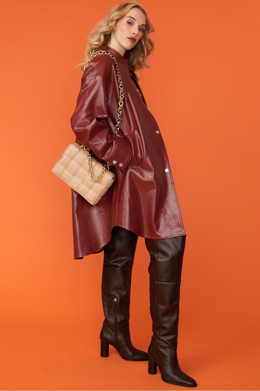 Deep red oversized faux leather trench coat with exaggerated collar and long hemline
